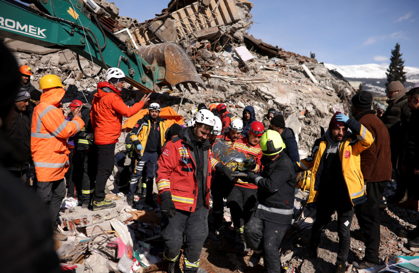  Rescuers carry a survivor at the site of a collapsed building, in the aftermath of a deadly earthquake in Kahramanmaras, Turkey February 8, 2023.  (photo credit: STOYAN NENOV/REUTERS)