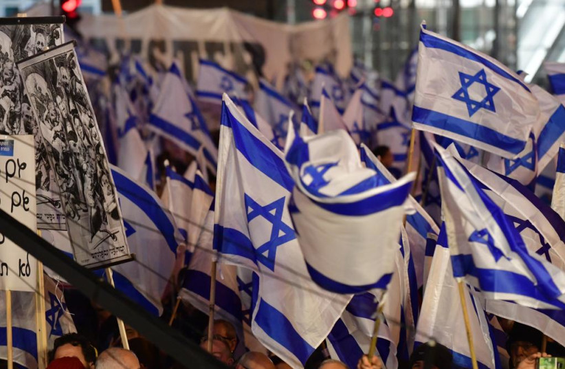 People gather with Israeli flags to protest against the government and the proposed judicial reforms, Tel Aviv, February 18, 2023. (photo credit: AVSHALOM SASSONI/MAARIV)
