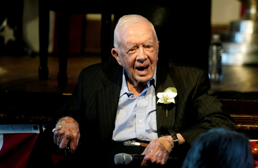 Former US President Jimmy Carter reacts as his wife Rosalynn Carter (not pictured) speaks during a reception to celebrate their 75th wedding anniversary in Plains, Georgia, US, July 10, 2021. (credit: JOHN BAZEMORE/POOL VIA REUTERS/FILE PHOTO)