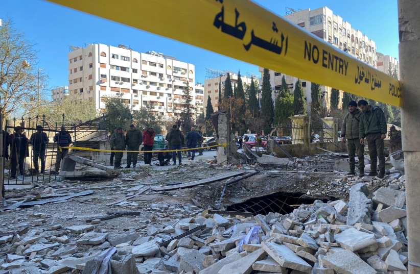  Agentes de policía sobre los escombros de un edificio dañado en el lugar de un ataque con cohetes, en el barrio de Kafr Sousa, en el centro de Damasco, Siria, 19 de febrero de 2023. (crédito: FIRAS MAKDESI/REUTERS)