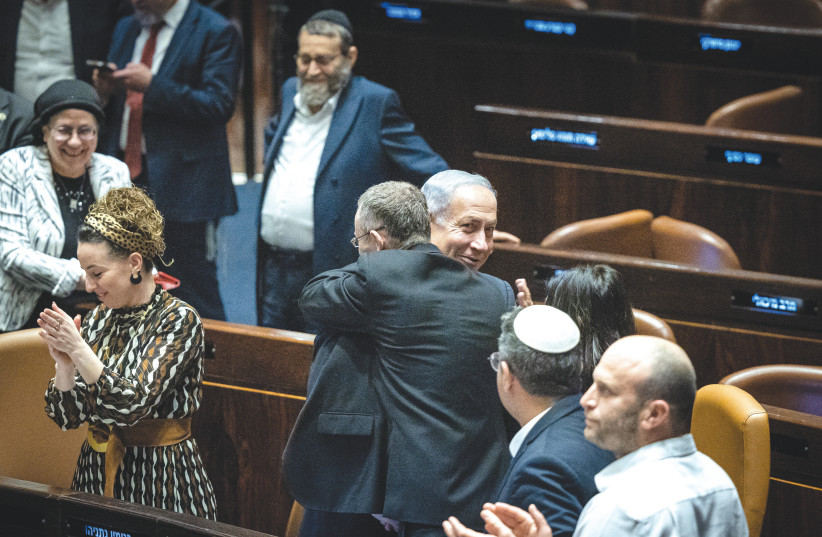  PRIME MINISTER Benjamin Netanyahu and Justice Minister Yariv Levin hug in the Knesset, as the coalition celebrates the passage of legislation, in a first reading, on judicial reform, early Tuesday morning.  (photo credit: YONATHAN SINDEL/FLASH90)