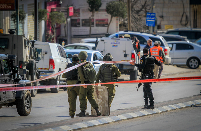 Israeli security forces secure the scene of a shooting attack where two Israelis were shot dead in Hawara, in the West Bank, near Nablus, February 26, 2023. (photo credit: NASSER ISHTAYEH/FLASH90)
