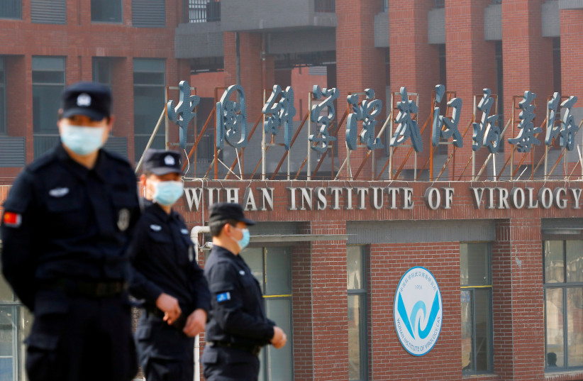  Security personnel keep watch outside the Wuhan Institute of Virology during the visit by the World Health Organization (WHO) team tasked with investigating the origins of the coronavirus disease (COVID-19), in Wuhan, Hubei province, China February 3, 2021.  (credit: REUTERS/THOMAS PETER/FILE PHOTO)