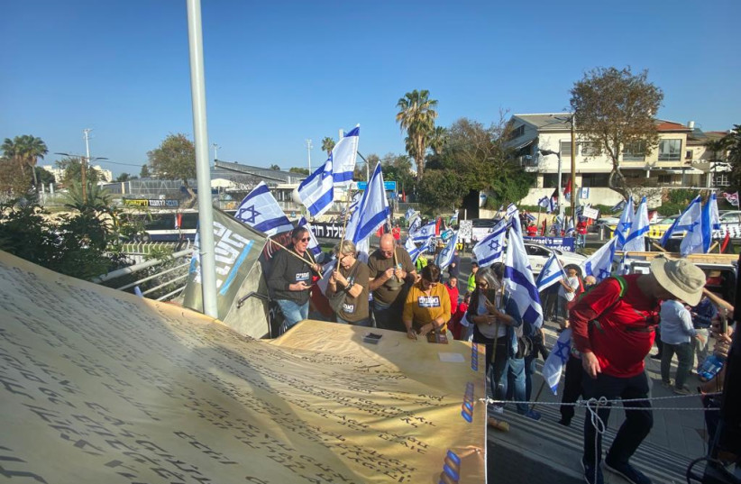  Protesters against judicial reform sign a large mockup of Israel's Declaration of Independence, March 1, 2023. (credit: AVSHALOM SASSONI/MAARIV)