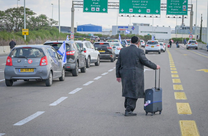 Man walks down the highway toward Ben-Gurion Airport as traffic is stopped during the judicial reform protests on March 9, 2023.  (credit: BEN COHEN MEGAPHONE NEWS)