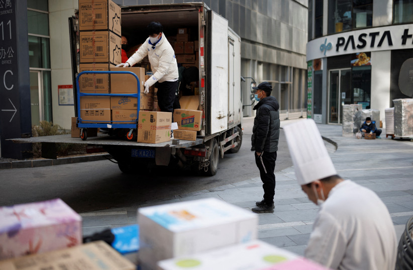 Delivery workers unload packages in a shopping district as China returns to work despite continuing coronavirus disease (COVID-19) outbreaks in Beijing, China, January 3, 2023. (credit: THOMAS PETER/REUTERS)