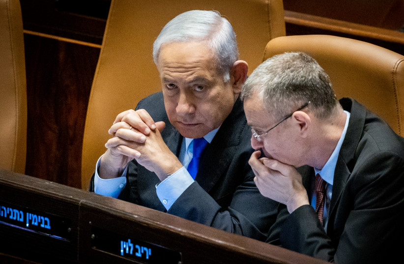  Benjamin Netanyahu with Justice Minister Yariv Levin during a discussion and a vote in the assembly hall of the Knesset, the Israeli parliament in Jerusalem, on March 6, 2023 (photo credit: Yonatan Sindel/Flash90/Reuters)