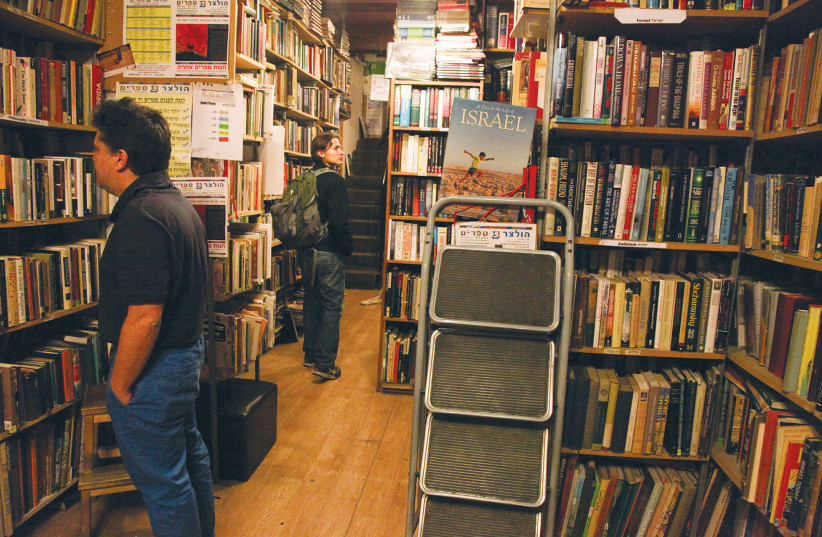  CUSTOMERS REVIEW the shelves at a Jerusalem bookstore. (photo credit: MEITAL COHEN/FLASH90)