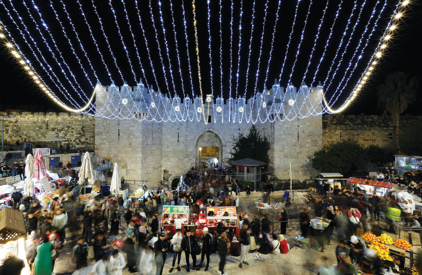  PALESTINIANS GATHER at Damascus Gate at the beginning of Ramadan in Jerusalem’s Old City, Wednesday. (credit: AMMAR AWAD/REUTERS)