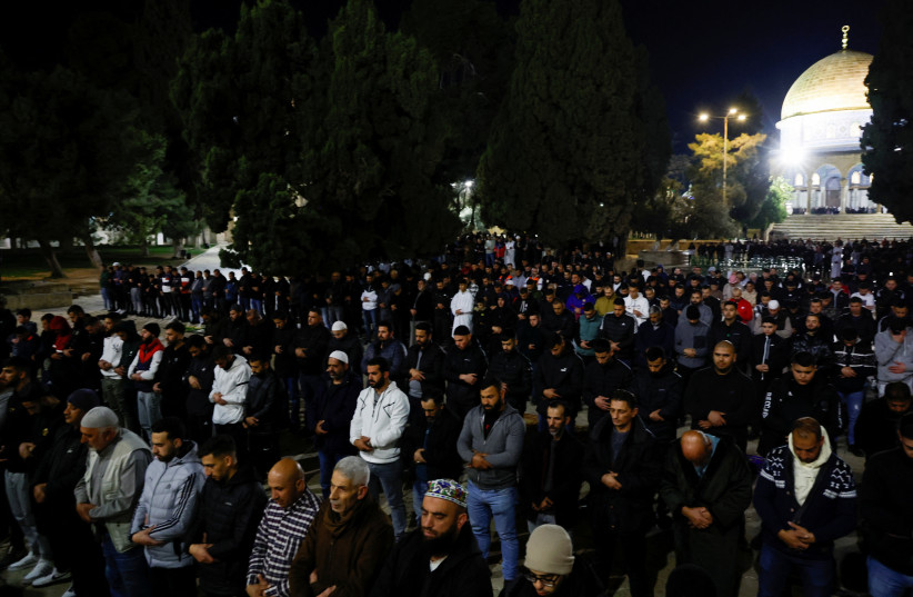  Palestinians perform dawn prayers during the first Friday of the holy month of Ramadan by the Dome of the Rock on the compound known to Muslims as the Noble Sanctuary and to Jews as the Temple Mount, in Jerusalem's Old City March 24, 2023.  (photo credit: AMMAR AWAD/REUTERS)