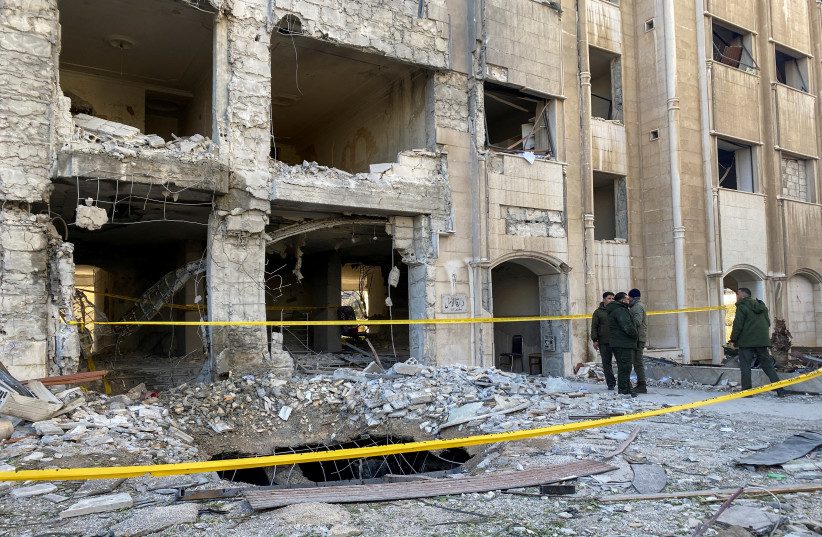  FILE PHOTO: Police officers stand near a damaged building at the site of a rocket attack in the Kafr Sousa neighbourhood of central Damscus, Syria, February 19, 2023.  (photo credit: FIRAS MAKDESI/REUTERS)