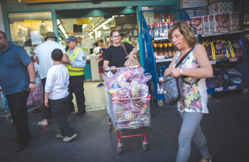  SHOPPING CARTS are full and supermarkets do a brisk business ahead of Passover.  (photo credit: HADAS PARUSH/FLASH90)