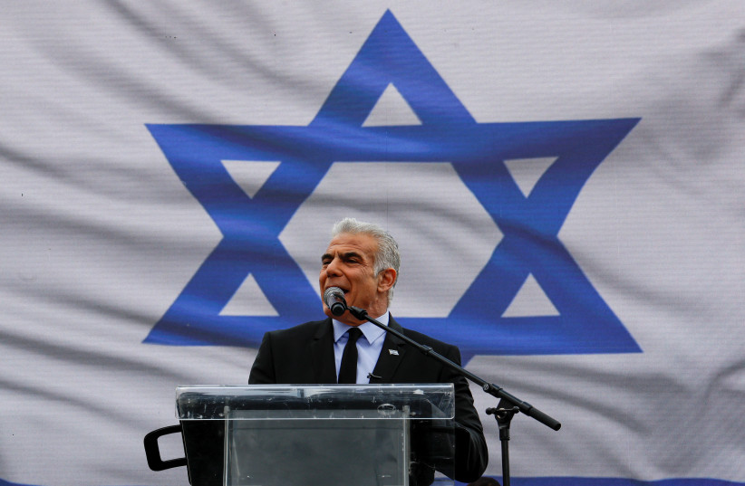  Israel's opposition leader Yair Lapid addresses protesters at a demonstration after against the government's judicial overhaul, in Jerusalem, March 27, 2023 (photo credit: AMMAR AWAD/REUTERS)