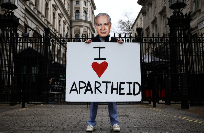 An activist from Amnesty International UK poses outside Downing Street wearing a mask depicting Israeli Prime Minister Benjamin Netanyahu, in London, Britain, March 23, 2023. (photo credit: REUTERS/HENRY NICHOLLS)