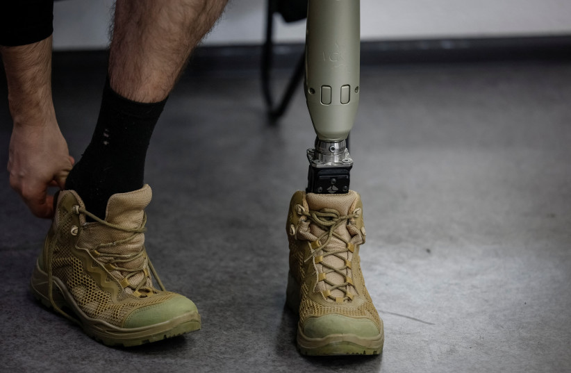  A patient of a prosthetics clinic, who lost his leg in the war, prepares to try on his prosthesis after fitting it in the clinic in Kyiv, Ukraine, March 9, 2023. (photo credit: REUTERS/ALINA YARYSH)