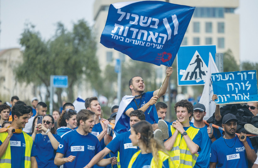  YOUTH DEMONSTRATE near the Knesset, last month. The flag reads: ‘For the unity: Youth march together.’ Don’t bet against Israel, it’s been counted out many times, and always bounced back strongly, says the writer. (photo credit: YONATAN SINDEL/FLASH90)