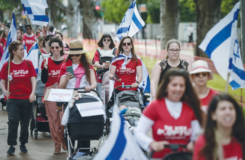  PARENTS MARCH with their small children against the government’s judicial overhaul, in Tel Aviv, last week. Their shirts read: ‘Mother of an anarchist’ - a cynical retort to accusations of anarchism. (photo credit: AVSHALOM SASSONI/FLASH90)