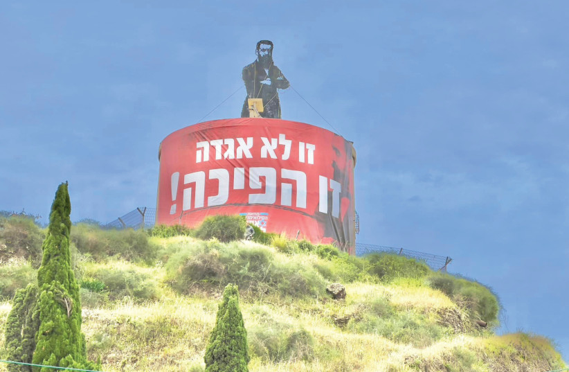  IN HERZLIYA, activists altered the Theodor Herzl monument created by Uri Lifschitz and wrapped it in a massive banner that reads ‘This is not a legend, this is a revolution!’ (photo credit: Rani Graf)