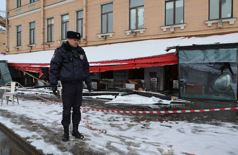  A police officer stands guard at the scene of the cafe explosion in which Russian military blogger Vladlen Tatarsky, (real name Maxim Fomin) was killed the day before in Saint Petersburg, Russia April 3, 2023. (photo credit: ANTON VAGANOV/ REUTERS)