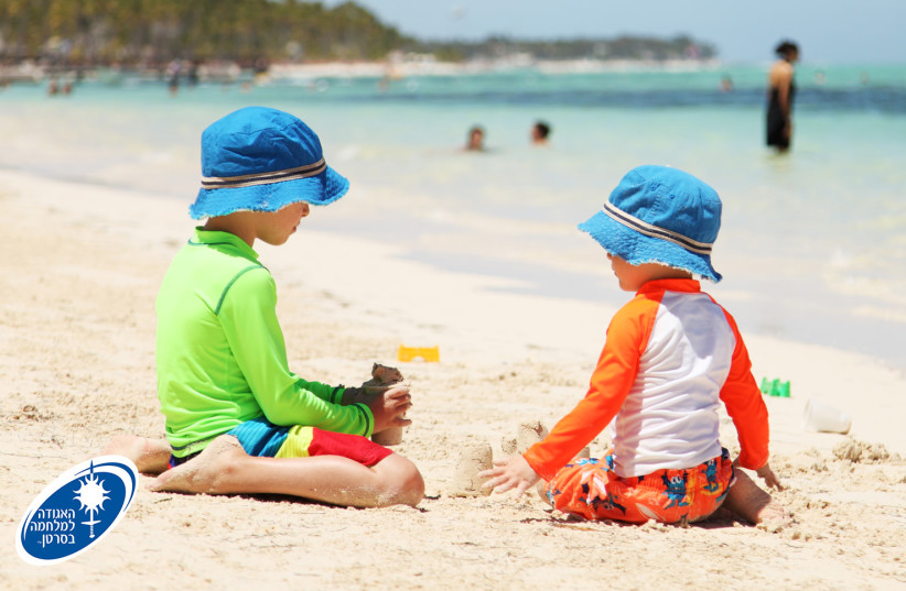  Two children sit on the beach. (photo credit: ISRAEL CANCER ASSOCIATION)