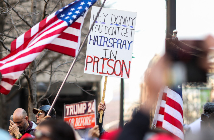 People against former U.S. President Donald Trump gather outside Manhattan Criminal Courthouse on the day of former U.S. President Donald Trump's planned court appearance after his indictment by a Manhattan grand jury following a probe into hush money paid to porn star Stormy Daniels, in New York Ci (photo credit: CAITLIN OCHS/REUTERS)