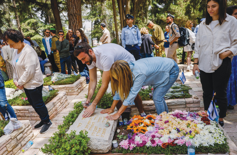  BEREAVED FAMILIES, friends and members of the security forces visit graves of fallen soldiers at the Mount Herzl Military Cemetery in Jerusalem, last year on Remembrance Day. (photo credit: OLIVIER FITOUSSI/FLASH90)