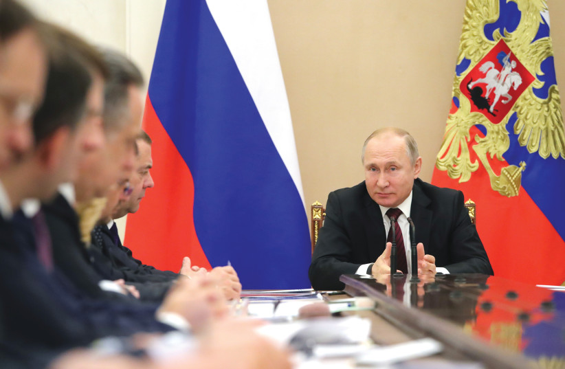  RUSSIA’S PRESIDENT Vladimir Putin chairs a meeting with members of the government at the Kremlin, last month. He has claimed that the economy has shrugged off the sanctions. (photo credit: Sputnik/Kremlin/Reuters)
