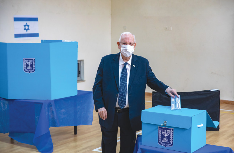  THEN-PRESIDENT Reuven Rivlin votes in the Knesset election, in Jerusalem, in March 2021. Voting in Israel is solely limited to a single ballot cast for a political party, not an individual.  (photo credit: OLIVIER FITOUSSI/FLASH90)