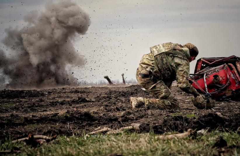  Ukrainian serviceman reacts as he throws a grenade during a training, amid Russia's invasion of Ukraine, in Donbas region, Ukraine April 8, 2023.  (photo credit: Yan Dorbronosov/Reuters)