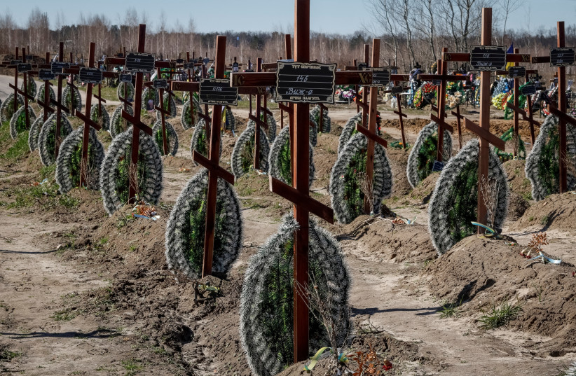   Graves of unidentified people killed by Russian soldiers during occupation of the Bucha town, are seen at the town's cemetery before the first anniversary of its liberation, amid Russia's attack on Ukraine, in the town of Bucha, outside Kyiv, Ukraine March 30, 2023.  (photo credit: REUTERS/GLEB GARANICH/FILE PHOTO)
