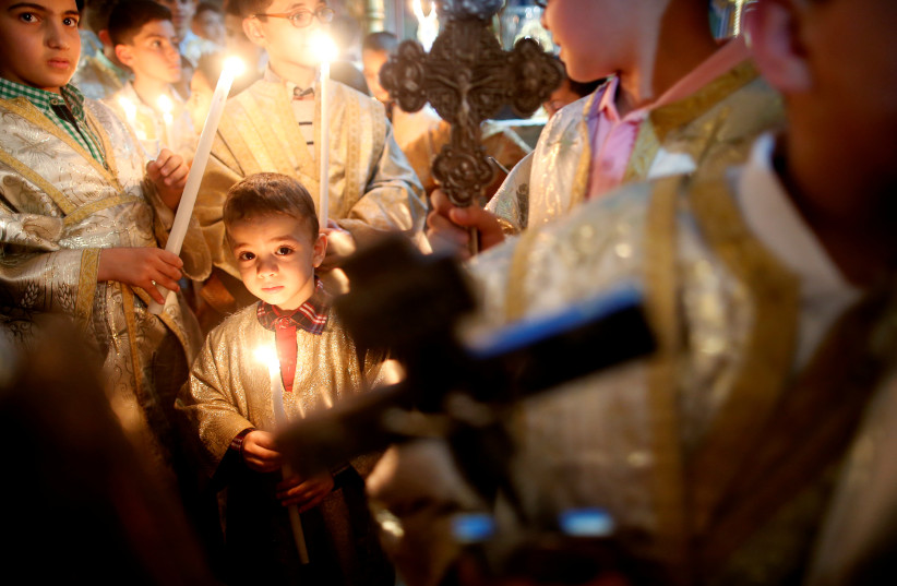  Palestinian Christians attend a service on Easter Sunday at the Saint Porfirios church in Gaza City April 1, 2018. (photo credit: REUTERS/SUHAIB SALEM)