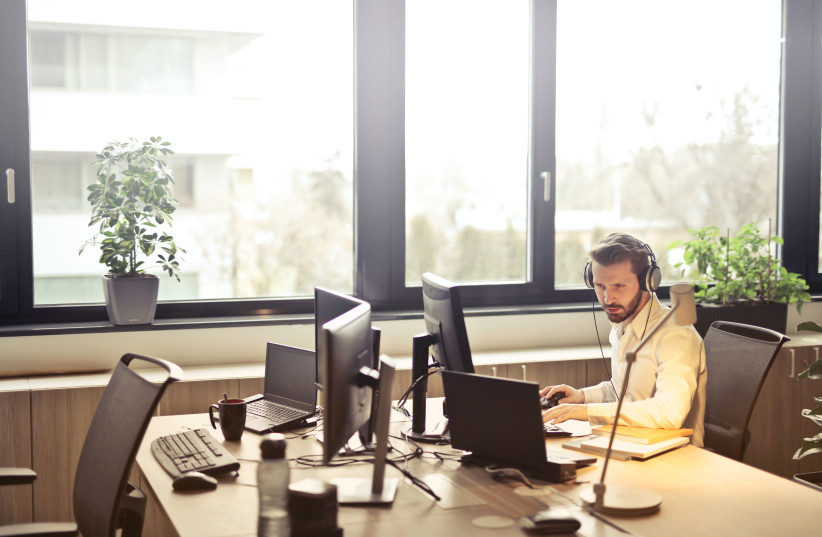  A man works in his office (illustrative) (photo credit: PEXELS)