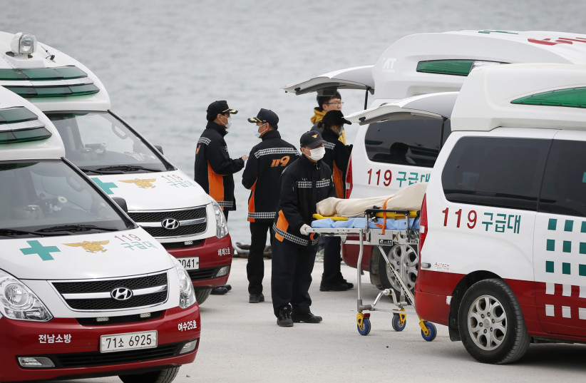  Emergency service workers place a body, recovered from the capsized passenger ship Sewol, into an ambulance at the port in Jindo April 22, 2014. (photo credit: KIM HONG-JI/ REUTERS)