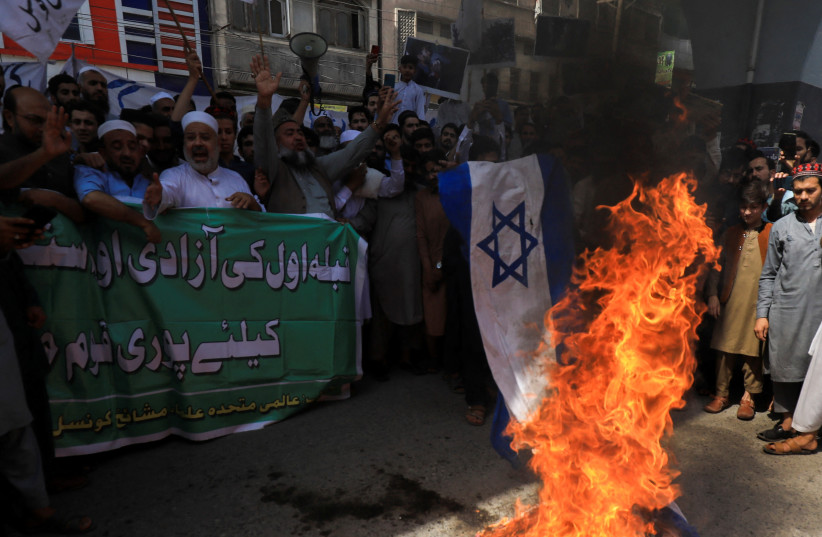  People chant slogans as they set fire to a representation of Israel's flag, marking al-Quds Day, (Jerusalem Day), during the fasting month of Ramadan in Peshawar, Pakistan April 14, 2023. (photo credit: Fayaz Aziz/Reuters)