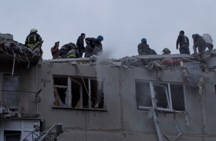 Emergency workers and volunteers work at the site of an apartment building damaged by a Russian military strike, amid Russia's attack on Ukraine, in Sloviansk, Donetsk region, Ukraine April 14, 2023. (photo credit: Anna Kudriavtseva/Reuters)
