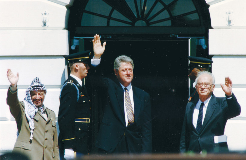  THEN-PRIME MINISTER Yitzhak Rabin, then-US President Bill Clinton and then-PLO chairman Yasser Arafat wave after the signing of the Israel-PLO Declaration of Principles, at the White House, 1993 (credit: GARY HERSHORN/REUTERS)
