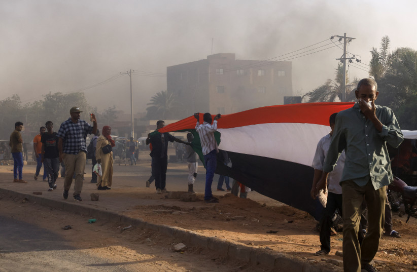 Protesters stand amidst the smoke from burning tyres during a rally marking the anniversary of the April uprising, in Khartoum, Sudan April 6, 2023. (photo credit: REUTERS/MOHAMED NURELDIN ABDALLAH)
