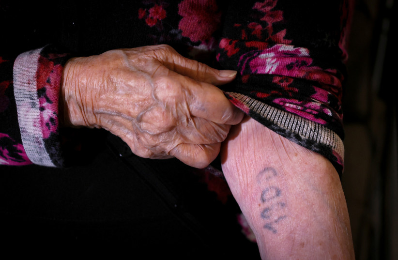  Holocaust survivor Judith Spielberger Mittelman, 96, who was among 999 Jewish women and girls transported from Slovakia to the Auschwitz concentration camp in one of the first two transportations of women to the camp, shows the numbers tattooed on her arm, March 29, 2022. (credit: REUTERS/MIKE SEGAR)