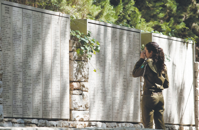  AN IDF soldier looks at names engraved on the Wall of Honor in the Garden of the Righteous Among the Nations at Yad Vashem. ‘In certain circles, the memory of the Righteous is used to suppress research on the Holocaust.’  (photo credit: DAVID VAAKNIN/ FLASH 90)
