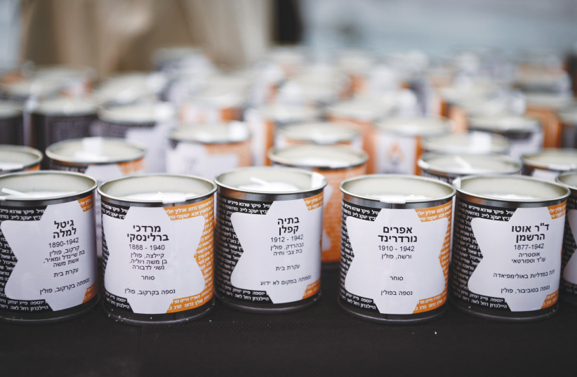  MEMORIAL CANDLES with the names and details of individuals murdered in the Holocaust are displayed at Dizengoff Square in Tel Aviv. Racism alone does not lead to the systematic genocide of an entire population. (photo credit: AVSHALOM SASSONI/FLASH90)