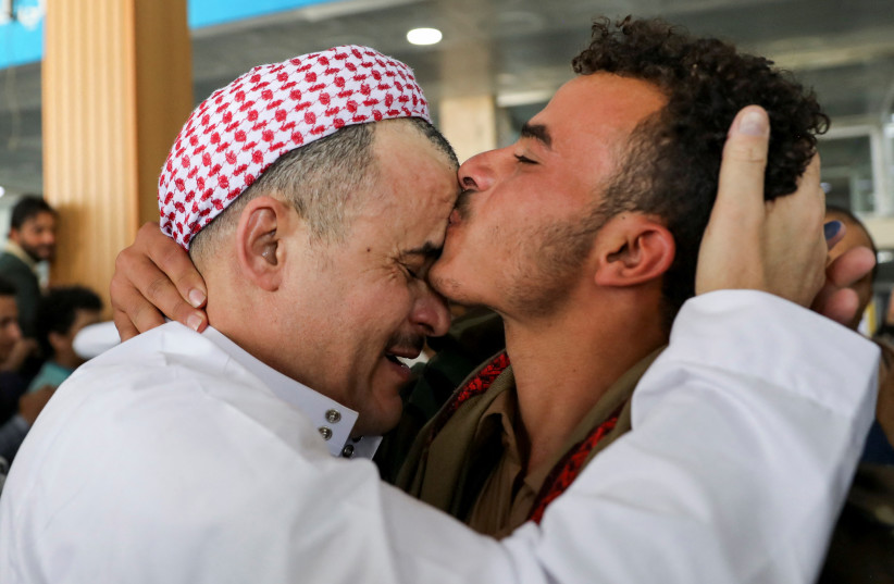  A freed detainee, released unilaterally by Saudi Arabia, embraces a relative at Sanaa Airport after arriving on an International Committee of the Red Cross (ICRC) plane, following three days of prisoner swaps between two sides in the Yemen conflict, in Sanaa, Yemen, April 17, 2023. (photo credit: KHALED ABDULLAH/REUTERS)