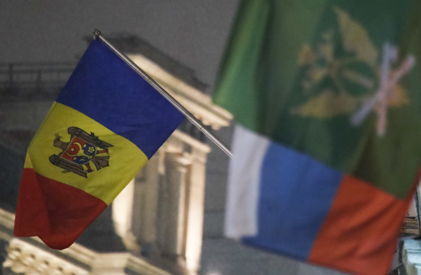  The state flag of Moldova (L) flies outside the country's embassy in central Moscow, Russia December 18, 2017 (credit: REUTERS/MAXIM SHEMETOV)