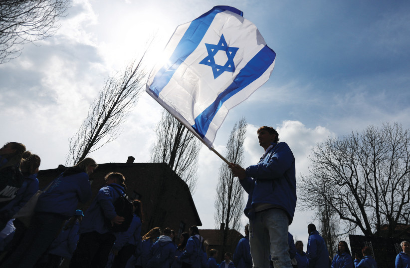  PARTICIPANTS WAVE Israeli flags Tuesday at annual International March of the Living on the grounds of the former Nazi Auschwitz death camp in Oswiecim, Poland (photo credit: Jakub Porzycki/Agencja Wyborcza.pl/Reuters)