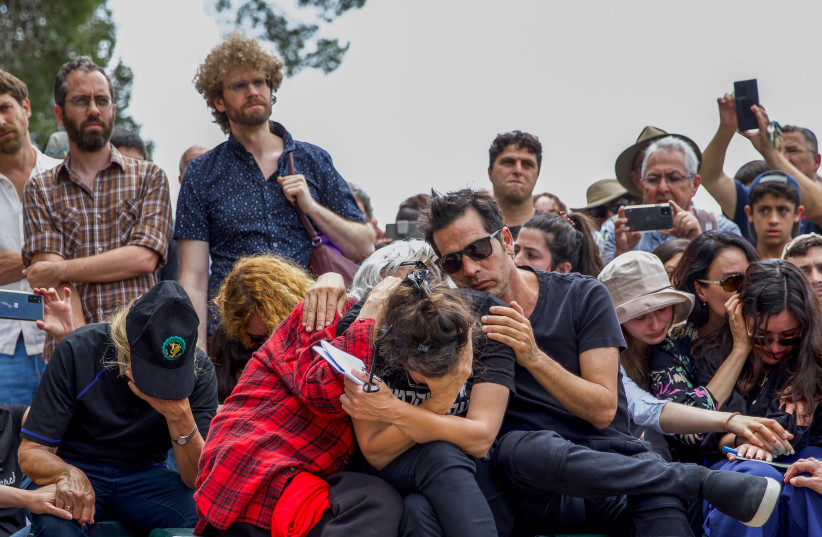 Friends and family members mourn during the funeral ceremony of Israeli author Yehonatan Geffen in Nahalal cemetery, northern Israel, April 21, 2023 (photo credit: SNIR TOREM/FLASH90)