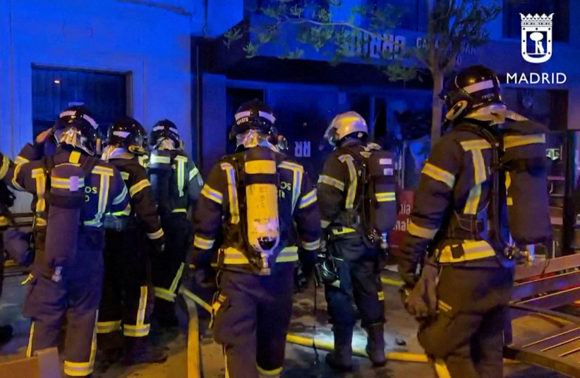  Firefighters gather outside a restaurant following a fire, in Madrid, Spain, April 21, 2023, in this screen grab taken from a handout video. (credit: Madrid Emergency Service/Handout via REUTERS)