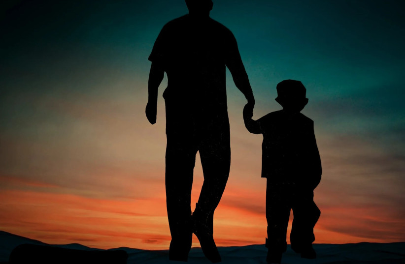  A father and son holding hands while walking (photo credit: PIXAHIVE)