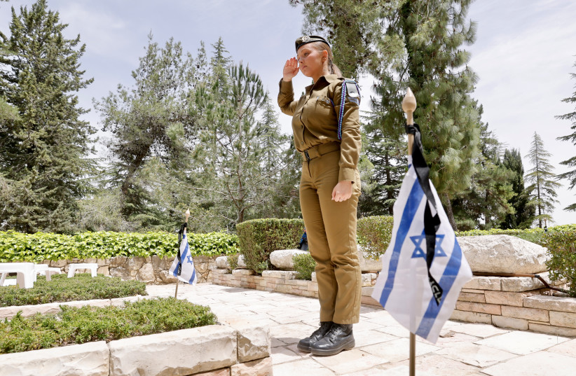  An IDF soldier salutes the grave of a fallen soldier at the Har Herzl military cemetery ahead of Israel's Remembrance Day, April 23, 2023. (credit: MARC ISRAEL SELLEM/THE JERUSALEM POST)