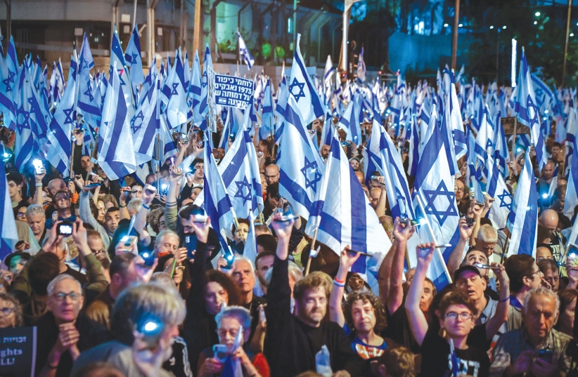 THOUSANDS PROTEST against the planned judicial overhaul, in Tel Aviv, on Saturday night. Men, women and children have taken to the streets and highways armed with nothing more than flags (credit: AVSHALOM SASSONI/FLASH90)