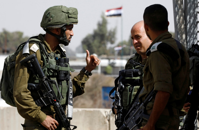 Israeli soldiers chat as they stand near the Quneitra crossing in the Golan Heights on the border line between Israel and Syria, October 15, 2018 (credit: AMIR COHEN/REUTERS)