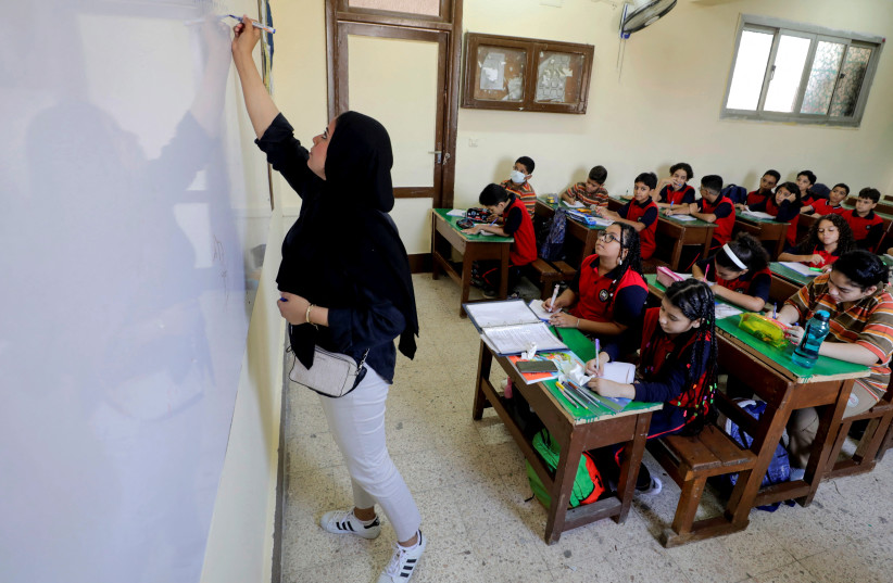  An Egyptian teacher instructs students on the first day's class at Martyr Rami school, in Cairo, Egypt, October 2, 2022. (photo credit: MOHAMED ABD EL-GHANY/REUTERS)